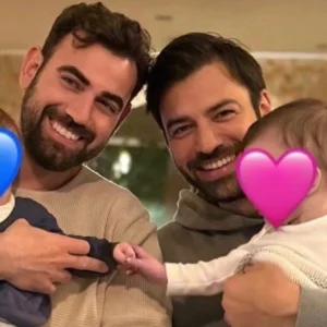 O Ανδρέας Γεωργίου και ο Νίκος Πολυδερόπουλος ποζάρουν μαζί, κρατώντας αγκαλιά τα παιδιά τους